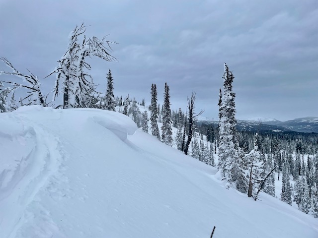 Gusty, Strong winds sending plumes of snow off peaks to the North