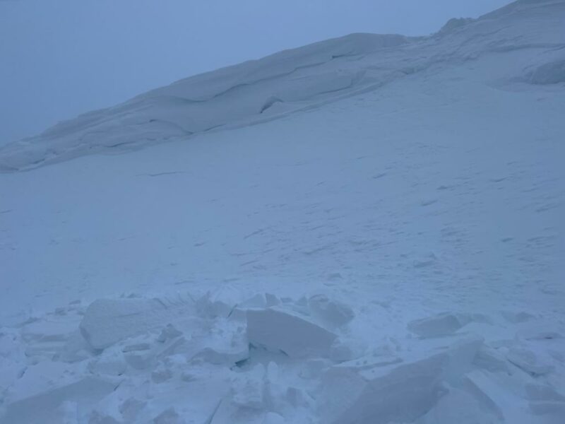 Standing at the top of the debris field looking up, the initiation point of the cornice fall can be seen at the top right.